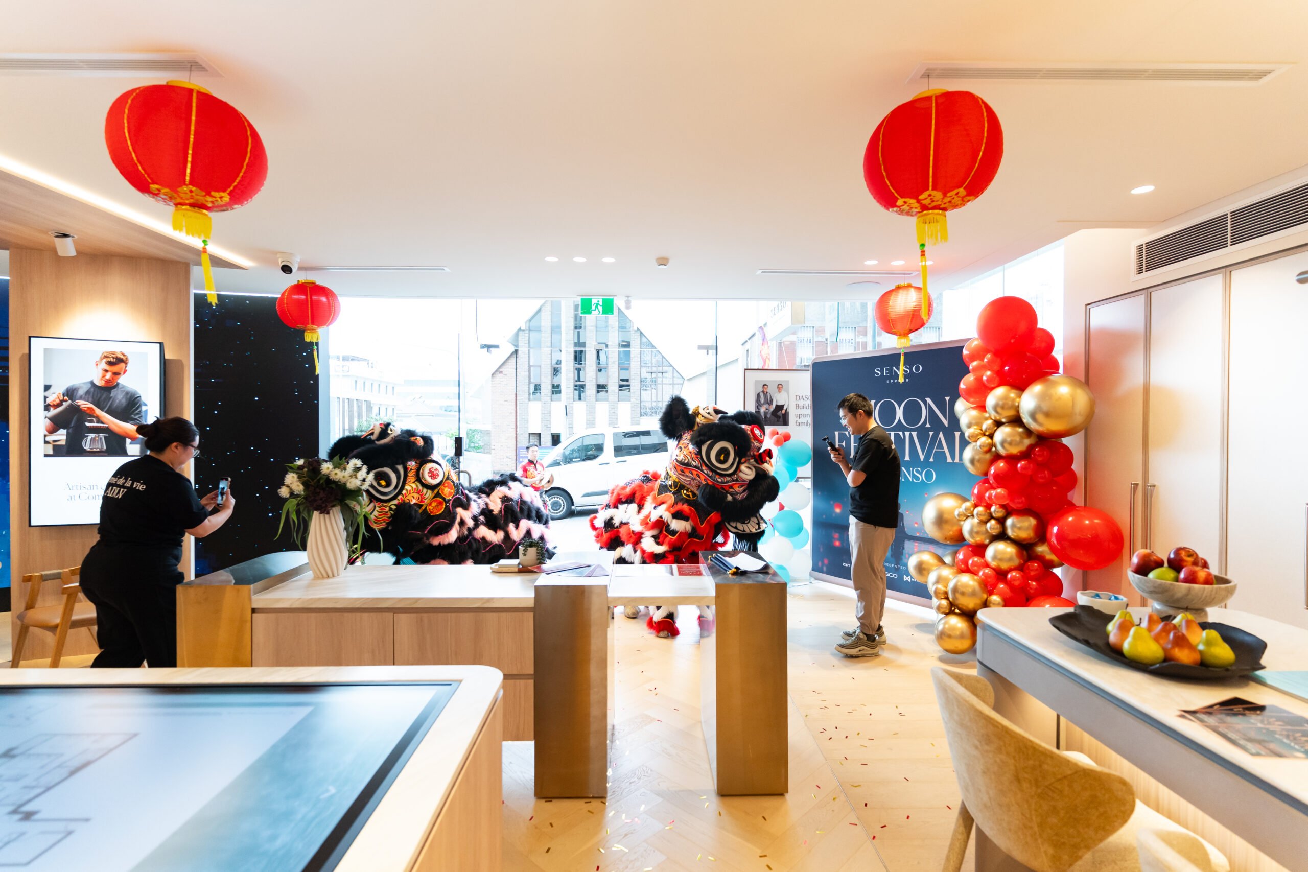 Moon Festival 2025 - lion dance performance at the SENSO display gallery in Epping with guests taking photos and enjoying the celebration.